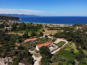 een luchtzicht op een huis op een heuvel naast de oceaan bij Dionysus Apartments & Suites in Ierissos