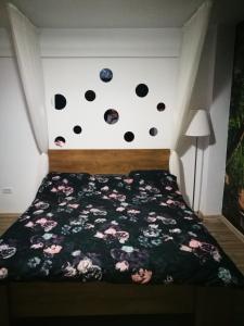 a bedroom with a bed with a black bedspread with polka dots at Iași Jacuzzi Apartment F in Iaşi +4 photos