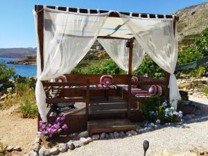 un cenador con sillas y flores en una playa en Sylvia's houses, en Kalymnos