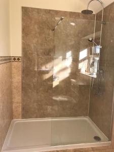 um chuveiro com uma porta de vidro na casa de banho em Little welham em Bedale