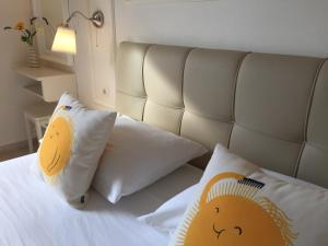 um quarto com uma cama branca e 2 almofadas em Alexandris Hotel em Spetses