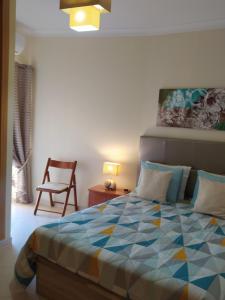 a bedroom with a bed and a table and a chair at Apartment My Site Alvor in Alvor