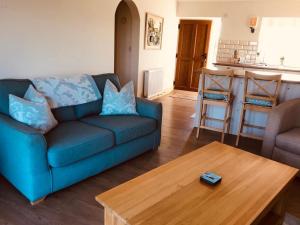 a living room with a blue couch and a wooden table at Little welham in Bedale