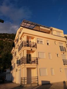 a tall yellow building with a balcony on it at Apartments st.Martinia in Ohrid
