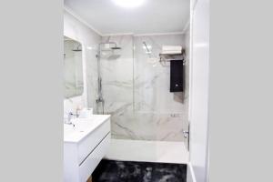 a bathroom with a shower and a sink at The Light House II, with rooftop and parking in Nazaré +11 photos