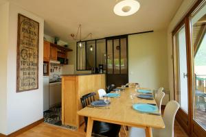 ein Esszimmer mit einem Tisch und einer Küche in der Unterkunft Les Aravis - Apartment for 6 people 5min from the lake in Giez