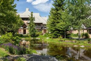 une maison avec un étang devant dans l'établissement Renovated & Spacious 1bed/2bath Whistler Village, à Whistler