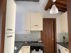 a kitchen with white cabinets and a stove top oven at Corte Navari - GuestHouse Fred in Pietrasanta