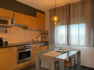uma cozinha com uma mesa e uma bancada em Apartamento Sanxenxo Vilalonga em Sanxenxo