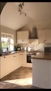 a kitchen with white cabinets and a counter top at Little welham in Bedale