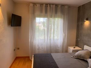 um quarto com uma cama e uma janela em Apartamento Sanxenxo Vilalonga em Sanxenxo