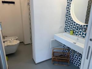 a bathroom with a sink and a mirror and a toilet at Le Casuzze Ammare in Favignana