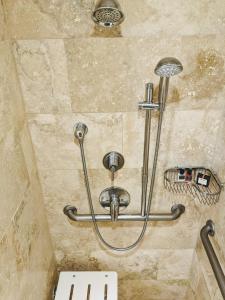 y baño con ducha y pared de piedra. en Omni Tucson National Resort en Tucson