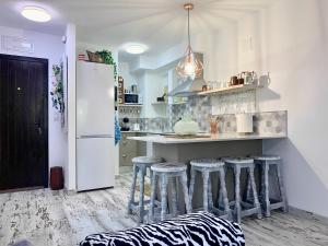 デニアにあるla felicidadのキッチン(白い冷蔵庫、バースツール付)