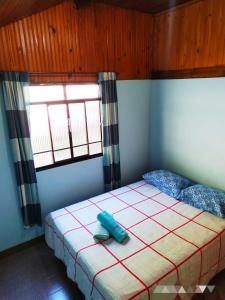 a bedroom with a bed and two windows at POUSADA DO BAR- BUDO in Itatiaia
