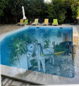 a statue of a donkey pulling a cart in a swimming pool at Ria Studios in Olhão