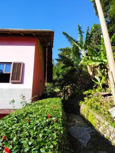 um caminho que leva a uma casa com vermelho e branco em POUSADA DO BAR- BUDO em Itatiaia