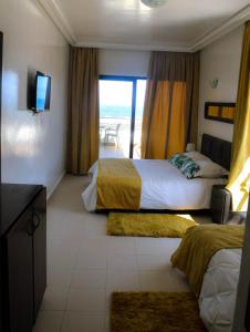a hotel room with two beds and a view of the beach at Auberge Oualidia Dream in Oualidia