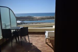 a table and chairs in a room with a view of the ocean at Auberge Oualidia Dream in Oualidia
