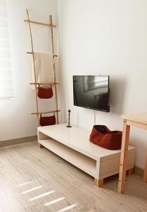 a living room with a tv on a white wall at La Casita del abuelo Javi in Cambados