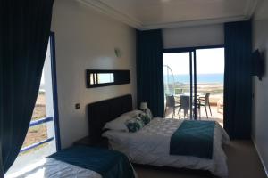 a bedroom with two beds and a view of the ocean at Auberge Oualidia Dream in Oualidia