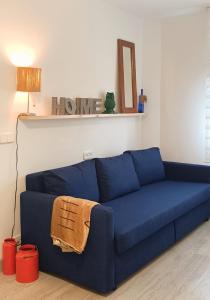 Sofá azul en la sala de estar con lámpara en La Casita del abuelo Javi, en Cambados