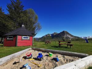 a sandbox with toys in the sand next to a picnic table at Reipå Camping in Reipå +76 photos