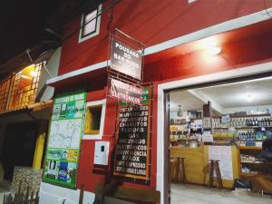 a store with a red building with signs on it at POUSADA DO BAR- BUDO in Visconde De Maua