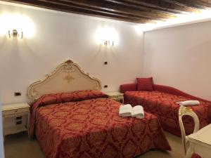una habitación de hotel con 2 camas y una silla en Hotel Leonardo en Venecia