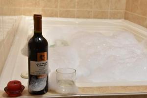 una bottiglia di vino e un bicchiere in una vasca da bagno di Hospedería Colonial de Villa de Leyva a Villa de Leyva
