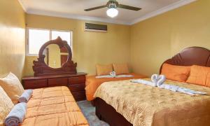 a bedroom with two beds and a mirror at Tropical Island Aparthotel, Budget Rooms & Family Apartment Rentals in Santo Domingo