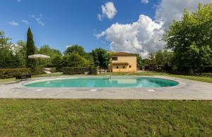 a swimming pool in a yard with a house in the background at Agriturismo La Fragola in Cignano