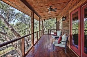 un porche cubierto con 2 sillas y ventilador de techo en Luxury Cabins @Stony Ridge-Ruby, en Wimberley