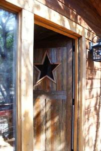 una puerta de madera con una estrella en el lateral de un edificio en Luxury Cabins @Stony Ridge-Ruby, en Wimberley