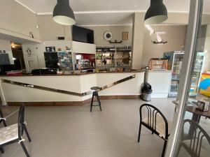 a bar in a restaurant with a counter and chairs at Hotel La Pergola in Loano