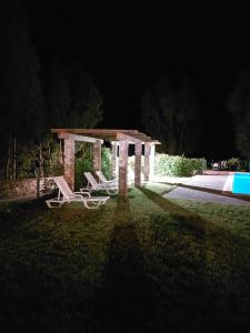a pavilion with two chairs in a yard at night at Monte Beato in Almodôvar