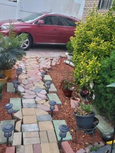 a garden with rocks and plants and a red car at Cozy & Relax LLC Airb&b in Brooklyn
