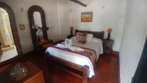 ein Schlafzimmer mit einem Bett und zwei Spiegeln in der Unterkunft Hospedería Colonial de Villa de Leyva in Villa de Leyva