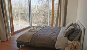 a large bed in a room with a large window at Luxury Duplex in Luxembourg Center Free Parking 5 min walk to the tram in Luxembourg