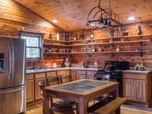 a kitchen with wooden walls and a table and a refrigerator at Fly Away Cabin- Modern, Serene, And Convenient in Compton