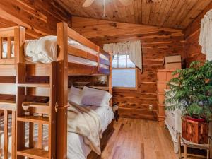 a bedroom with bunk beds in a log cabin at Fly Away Cabin- Modern, Serene, And Convenient in Compton