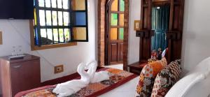 una stanza con un letto con un animale bianco sopra di Hospedería Colonial de Villa de Leyva a Villa de Leyva