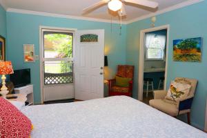 ウィンバリーにあるBandit's Hideaway-Rosey's Cottageの青い壁のベッドルーム1室、ベッド1台、窓が備わります。