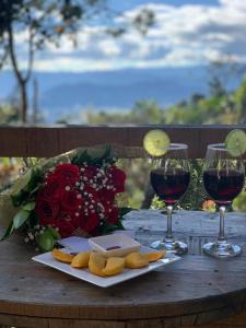 a wooden table with two glasses of wine and cheese at Cumbre Glamp in Tocancipá
