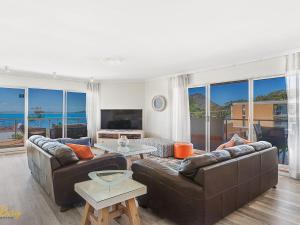 a living room with two couches and a table at Breakwater Apartment 205 in Shoal Bay