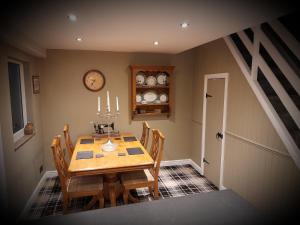 a dining room with a wooden table and chairs at Stable cottage cozy,quirky with a hot tub in Bridlington
