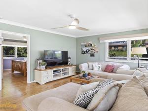 ein Wohnzimmer mit 2 Sofas und einem TV in der Unterkunft Morton Cottage at Lemon Tree in Lemon Tree Passage