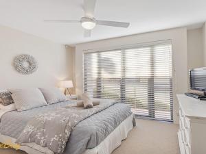 a bedroom with a bed and a large window at Wanda Beach Unit 2 Soldiers Point Road in Salamander Bay