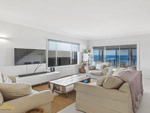 a living room with two couches and a flat screen tv at Elanora Ocean St No 8 in Anna Bay
