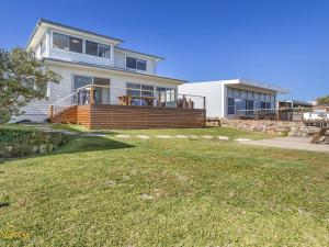 una casa grande con una gran terraza en el césped en Elanora Ocean St No 8 en Anna Bay